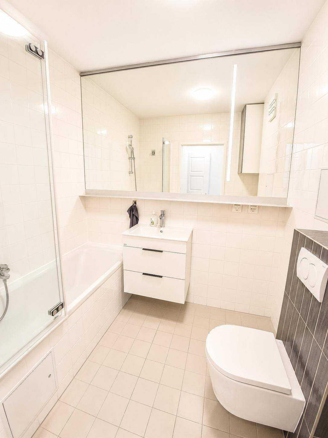 Modernes Badezimmer mit Badewanne, Waschtisch und wandhängendem WC.