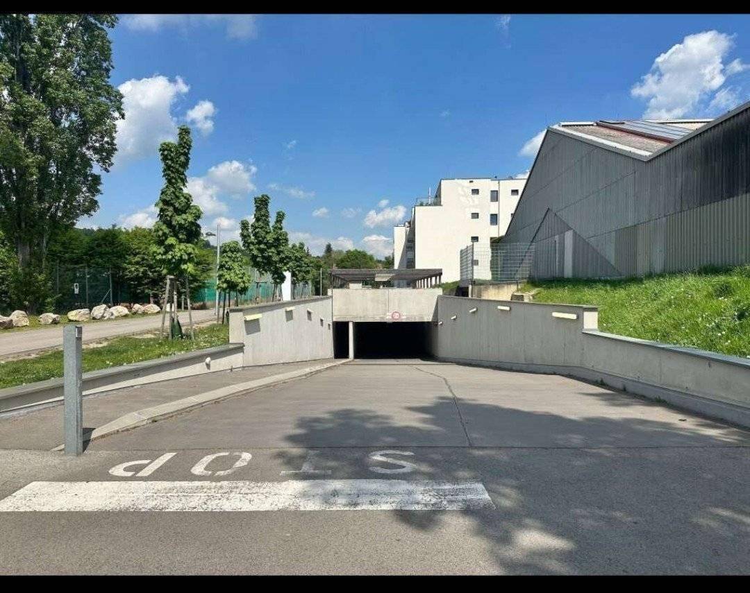 Einfahrt zur Tiefgarage der Wohnanlage unter blauem Himmel.