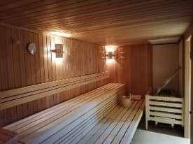 Traditionelle Holzsauna mit Bänken und Saunaofen für Entspannung.