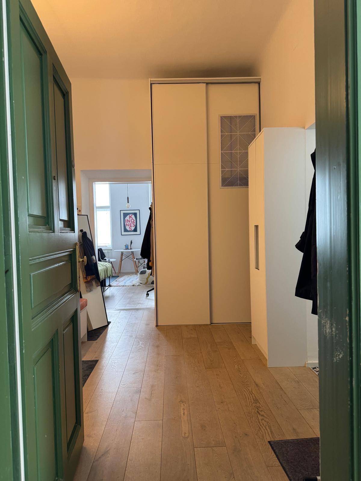 Langer Flur mit Einbauschrank, der in den hellen Wohnbereich führt.