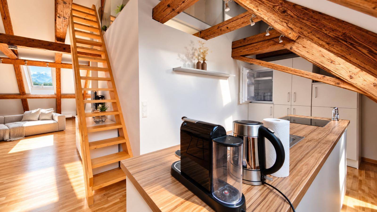 Moderne Küchenzeile mit Kaffeemaschine und Wasserkocher, integriert in den offenen Wohnbereich.