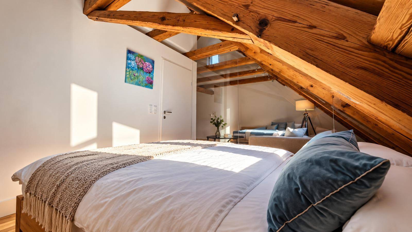 Schlafzimmer mit Holzbalken und Blick auf den offenen Wohnbereich, getrennt durch eine Glaswand.