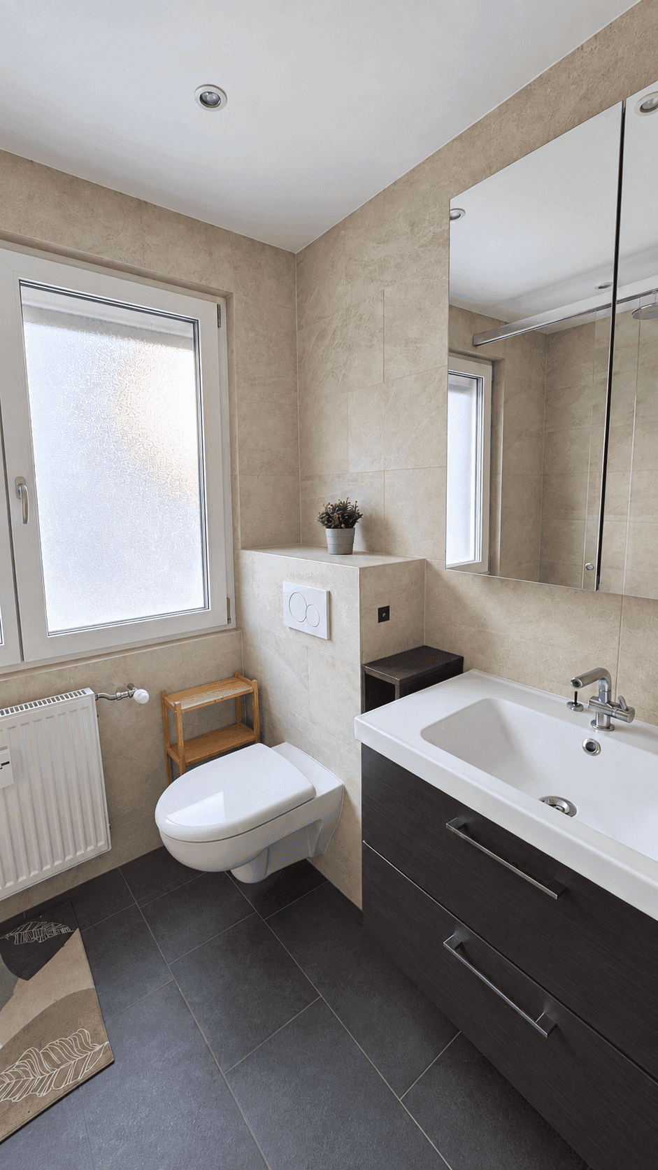 Modernes Gäste-WC mit Wand-WC, Einzelwaschbecken und Fenster für Tageslicht.