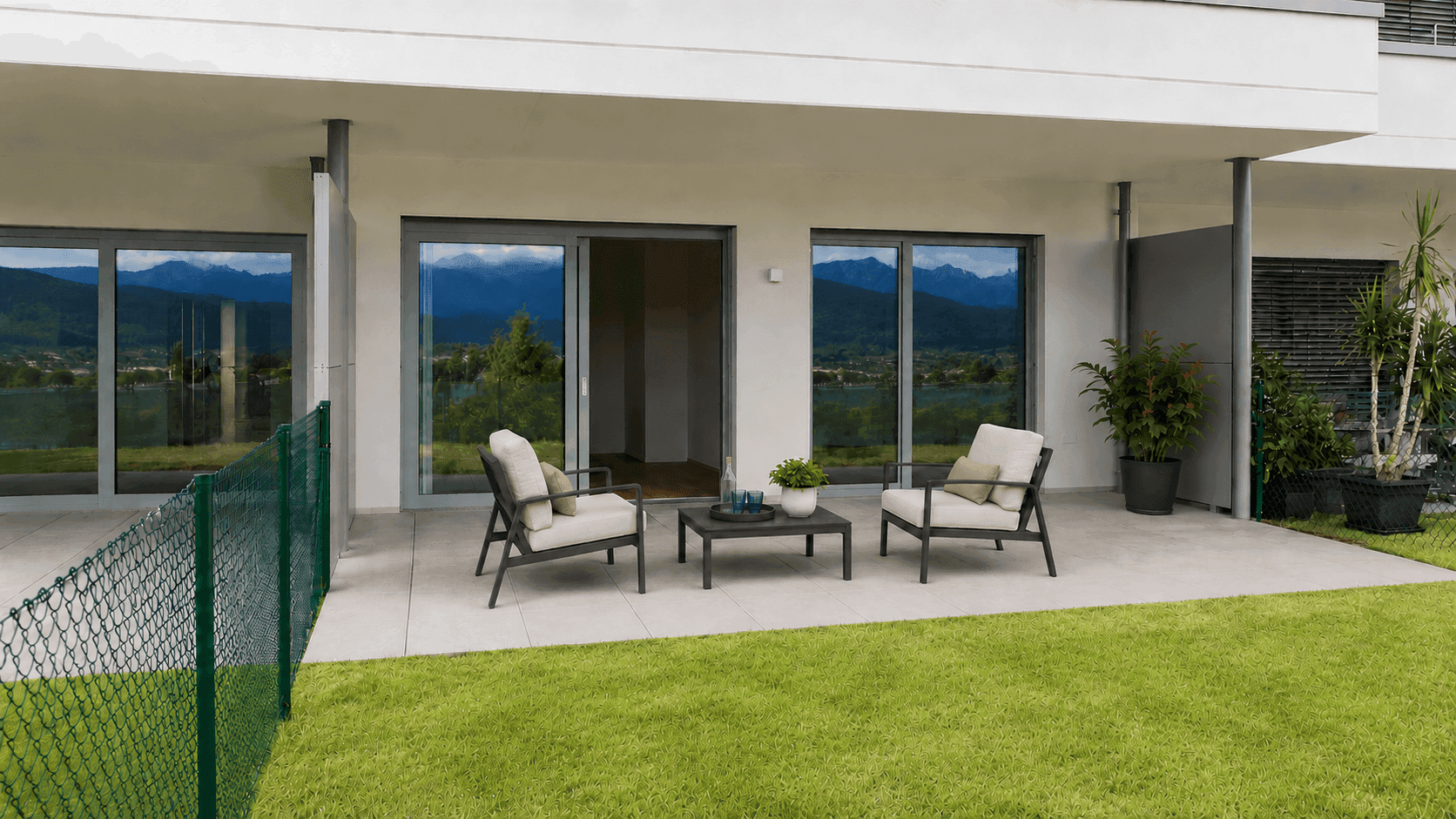 Geräumige Terrasse mit Sitzgelegenheiten und Zugang zum Garten, mit Bergblick durch die Fenster.