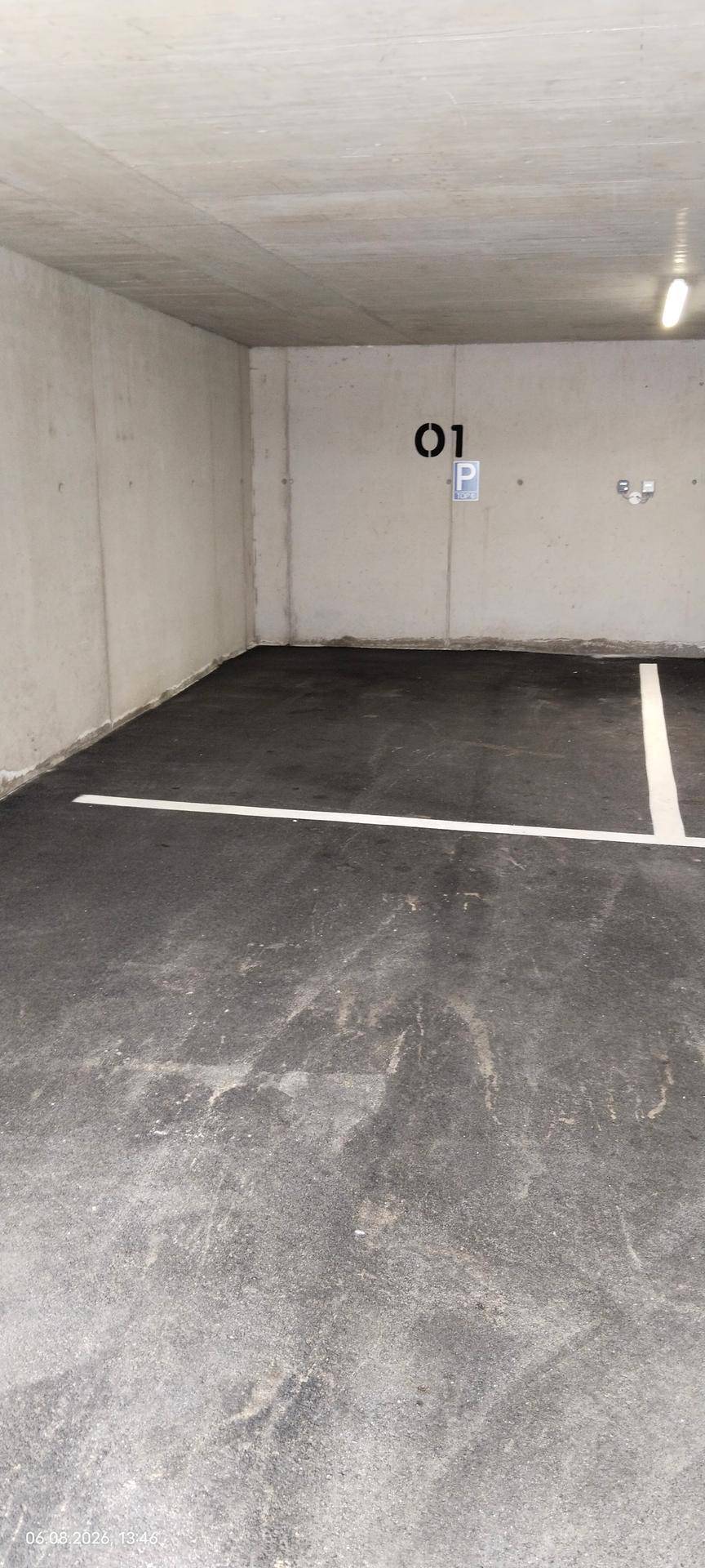 Geräumiger Tiefgaragenstellplatz mit klarer Markierung, Betonwänden und guter Beleuchtung.