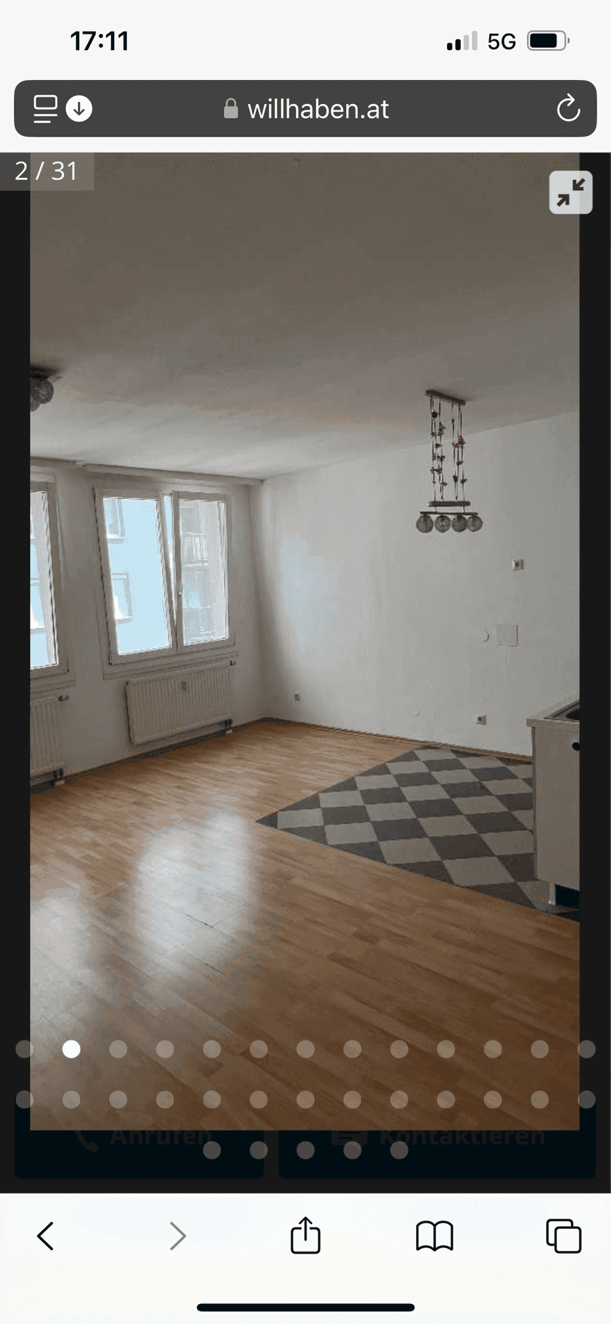 Geräumiger Wohnbereich mit Holzboden und dekorativem Fliesenmuster, hell durch große Fenster.