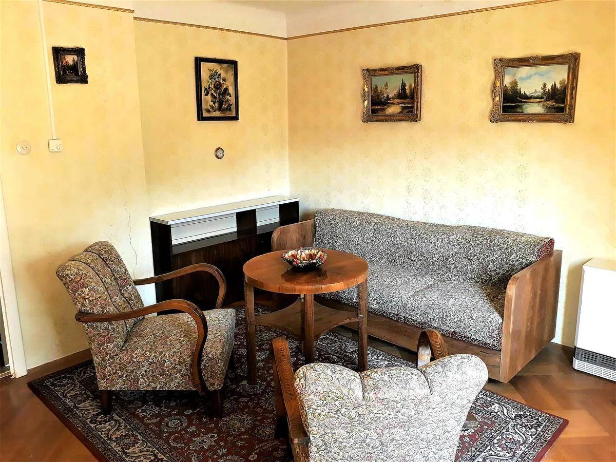 Gemütliches Wohnzimmer mit Vintage-Möbeln, Teppich und Holzparkett.