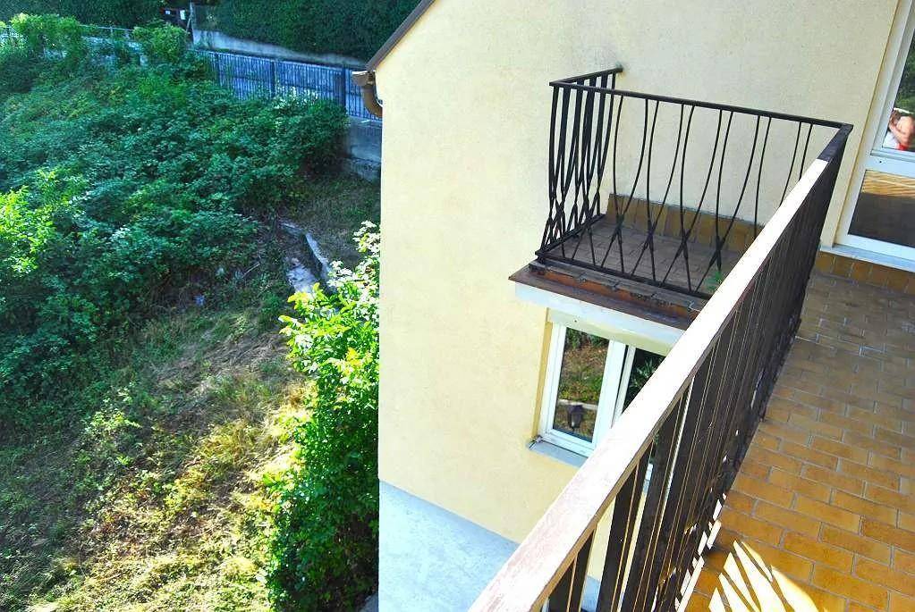 Balkon mit Blick auf das verwilderte Grundstück und einen französischen Balkon darunter.