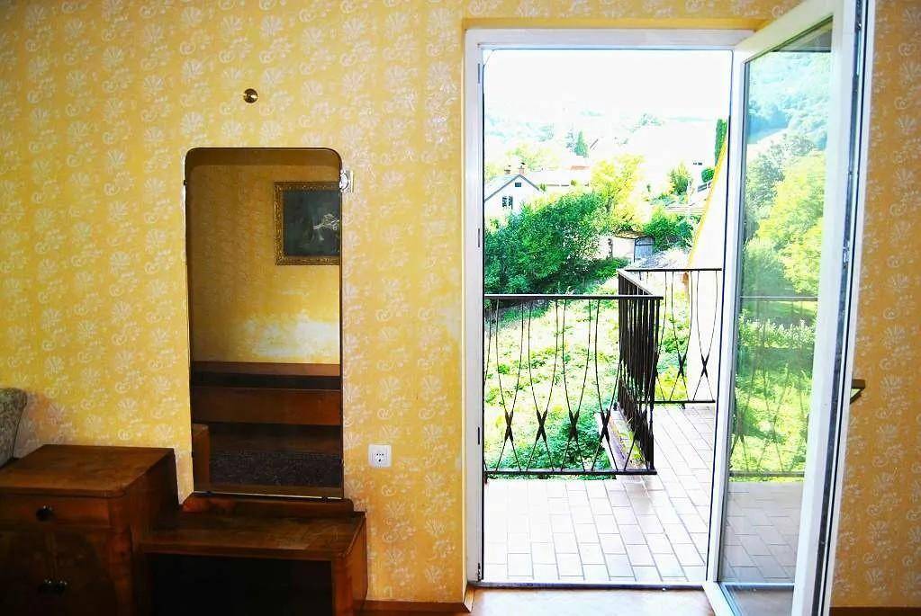 Innenraum mit gemusterten Tapeten und Zugang zu einem Balkon mit Weitblick.