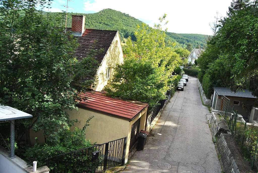 Blick auf die ruhige Wohnstraße mit dem Haus und umliegenden Bäumen.