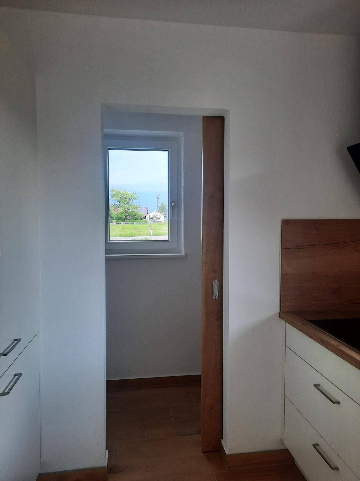 Praktischer Abstellraum oder Speisekammer mit Fenster, direkt angrenzend an die Küche.