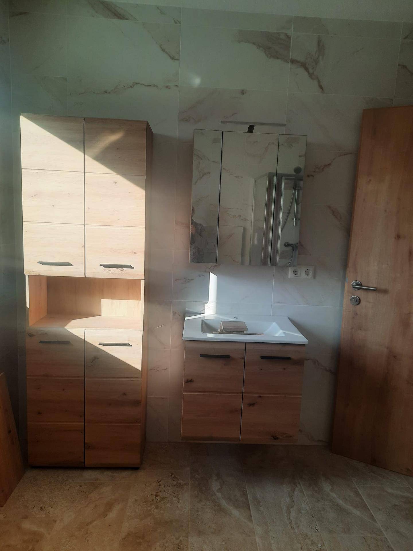 Modernes Badezimmer mit Holzwaschtisch, Spiegelschrank und viel Stauraum.