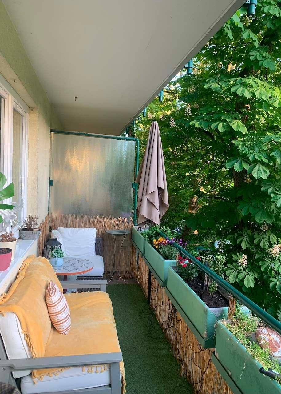 Gemütlicher Balkon mit Sitzgelegenheiten, Pflanzen und Blick ins Grüne, ideal zum Entspannen.