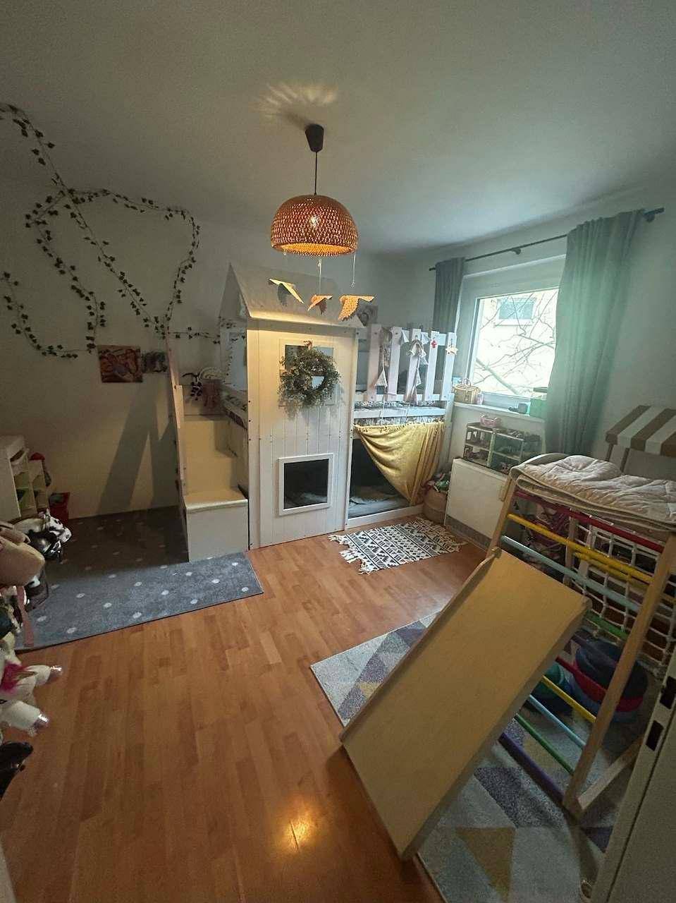 Kinderzimmer mit Spielbett, Rutsche und Holzboden, fantasievoll und kinderfreundlich gestaltet.