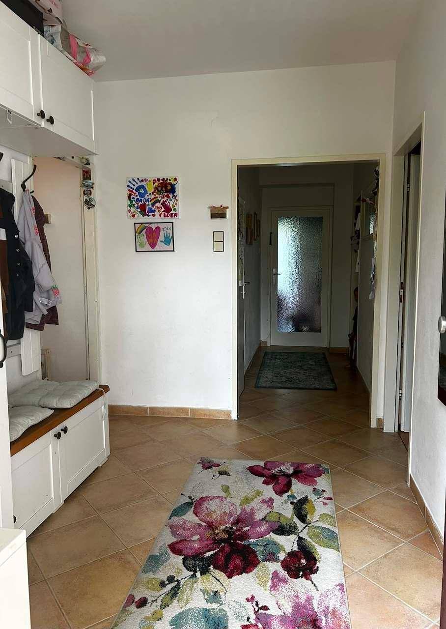 Heller Flur mit Fliesenboden, Garderobe und Sitzbank, einladend und praktisch gestaltet.