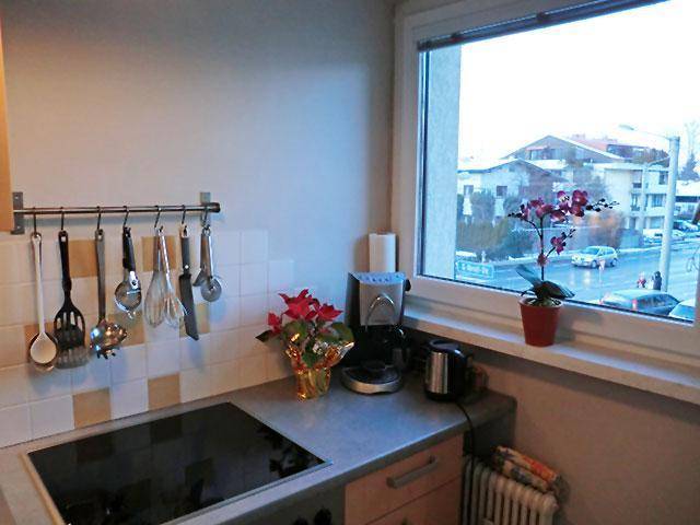 Küchenarbeitsplatte mit Induktionskochfeld, Kaffeemaschine und Fensterblick auf die Straße.