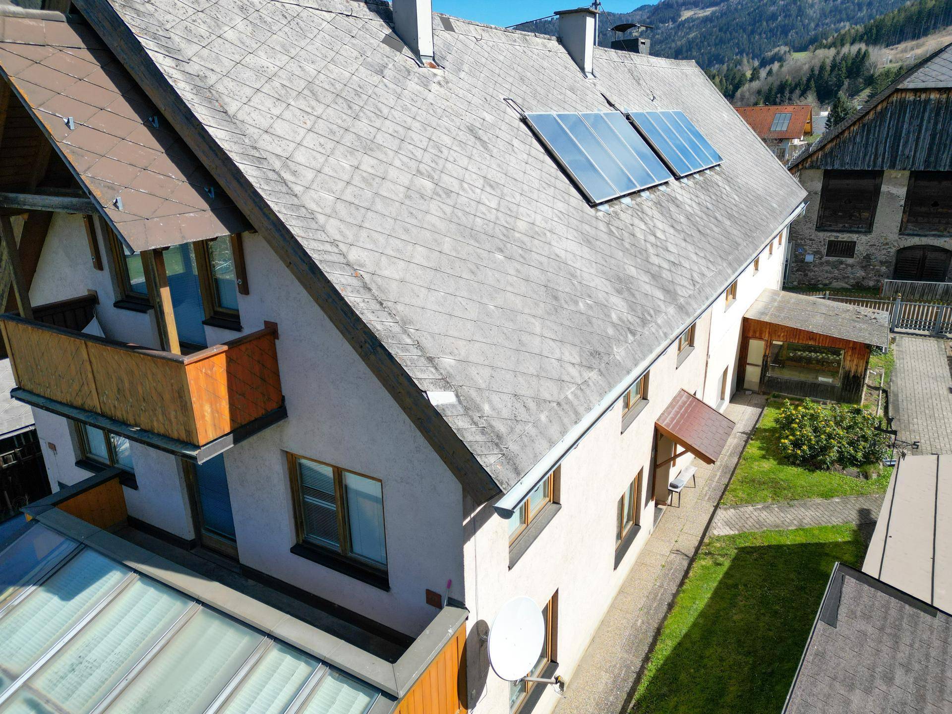 Ansicht des Wohnhauses mit Satteldach und installierten Solarpaneelen auf dem Dach.