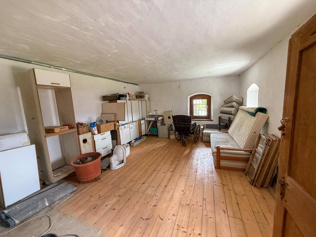 Geräumiger Dachboden oder Abstellraum mit Holzboden und einem Fenster, unmöbliert und hell.