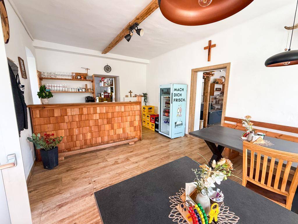 Gemütlicher Barbereich mit Holztheke, Sitzgelegenheiten und einem Getränkekühlschrank.