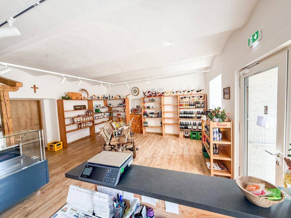 Geräumiger Verkaufsraum mit Theke, Waage und einer Vielzahl von Produkten in Holzregalen.