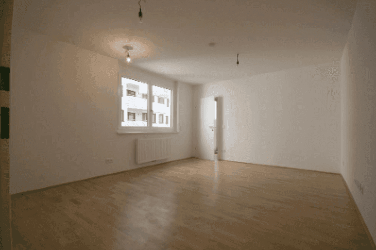 Helles, leeres Zimmer mit Parkettboden und großen Fenstern, bereit zur individuellen Gestaltung.