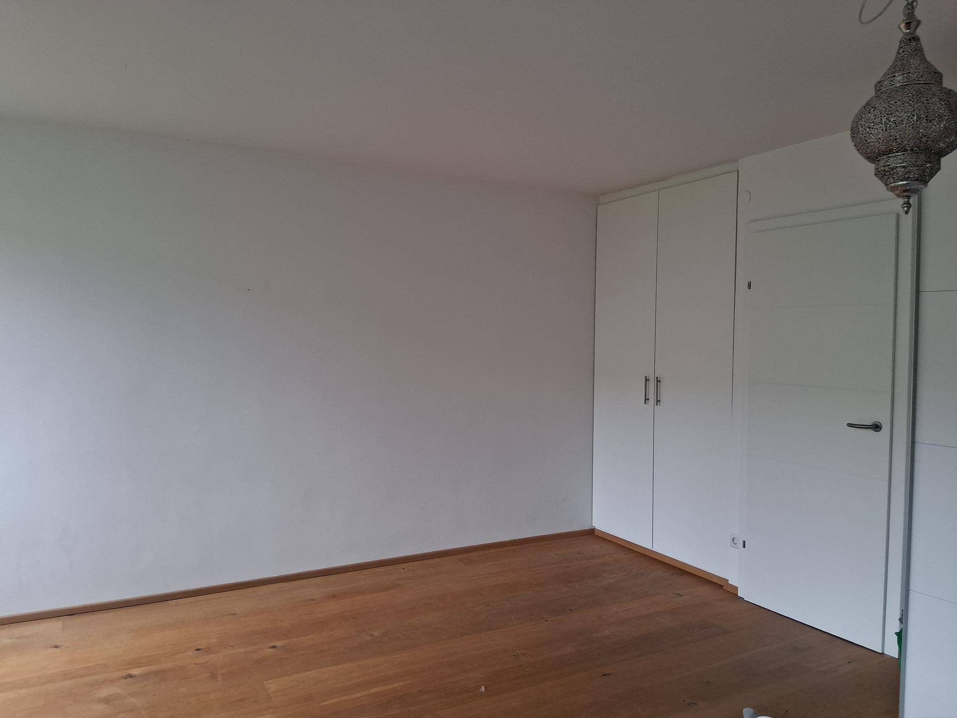 Schlafzimmer mit Holzboden und praktischen, raumhohen Einbauschränken für viel Stauraum.