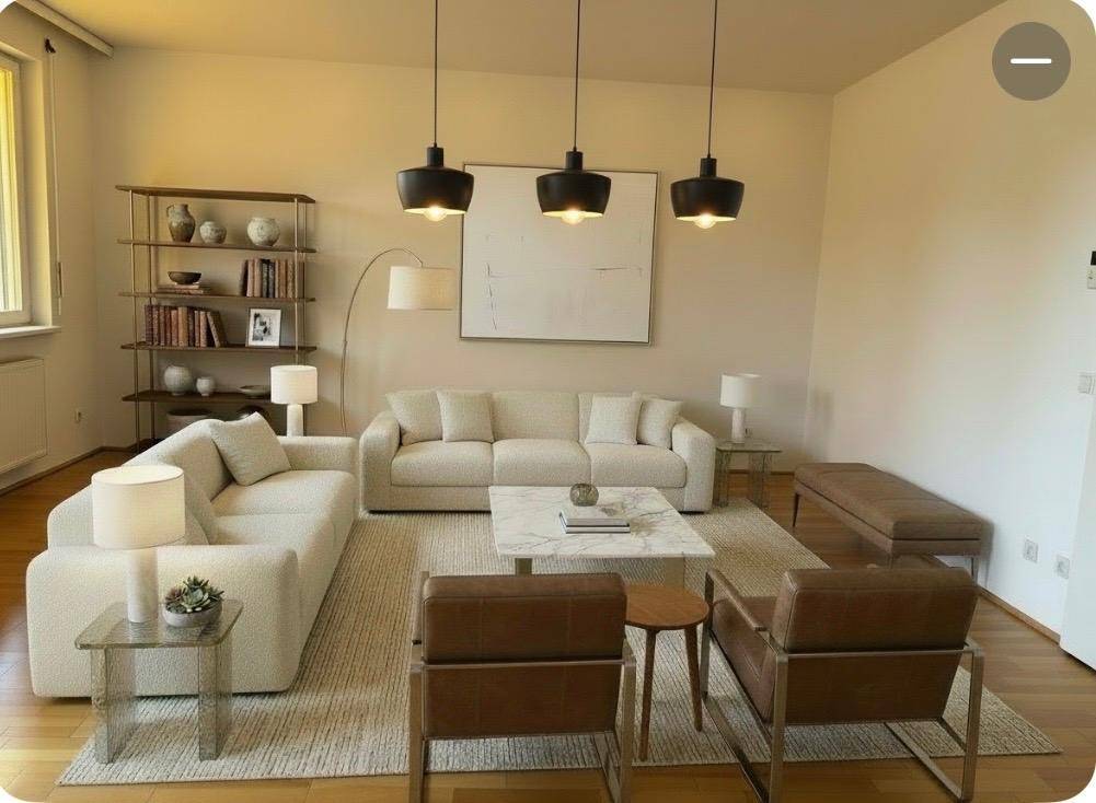 Helles, modern eingerichtetes Wohnzimmer mit bequemen Sofas, einem Marmor-Couchtisch und Holzboden.
