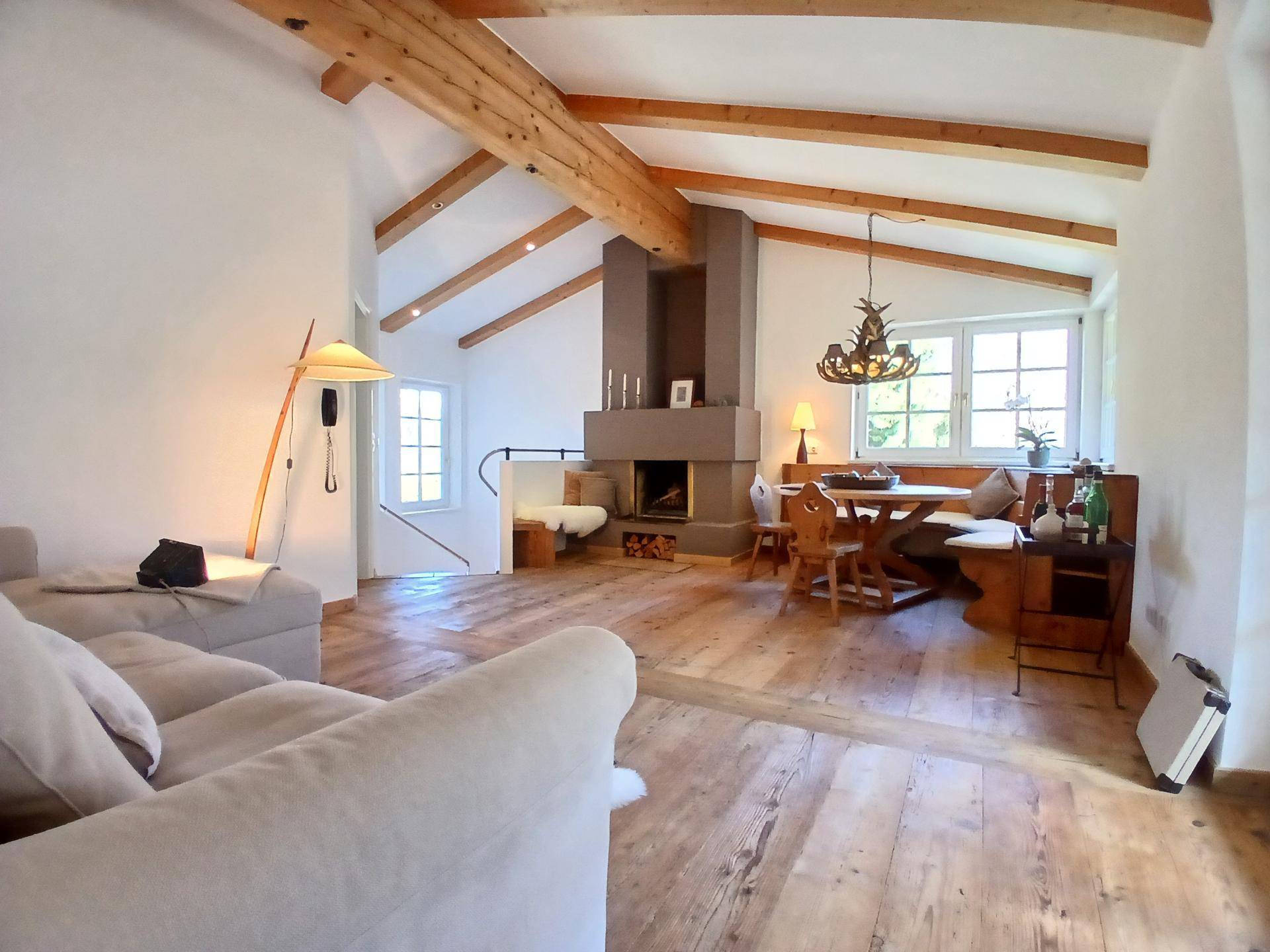 Geräumiger Wohn-Essbereich mit Holzbalken, Kamin und traditioneller Einrichtung.