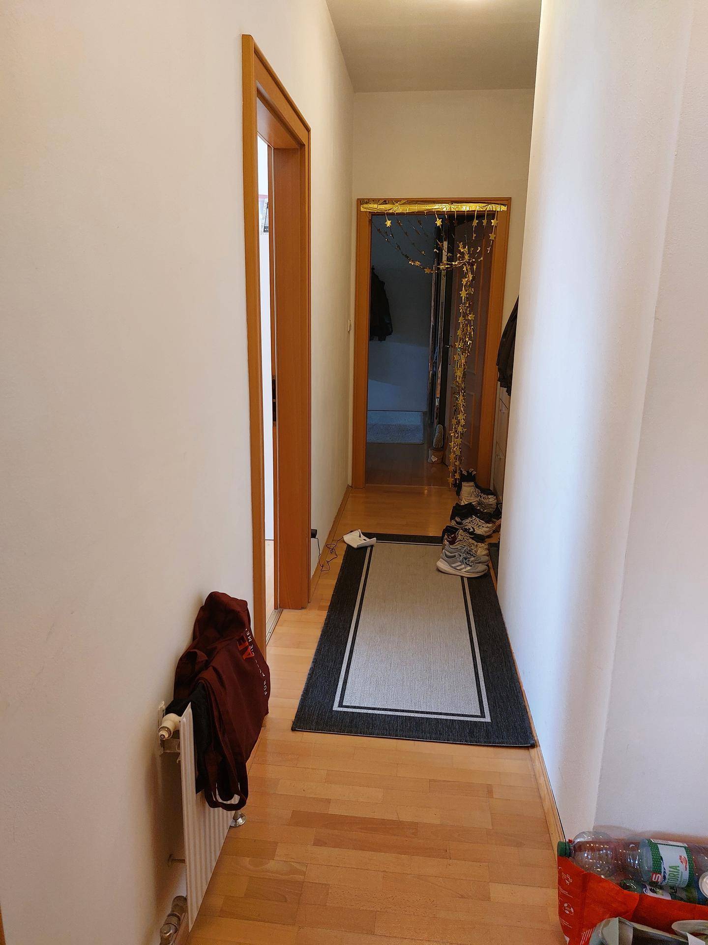 Heller Flur mit Laminatboden und Zugang zu weiteren Räumen in der Dachgeschosswohnung.