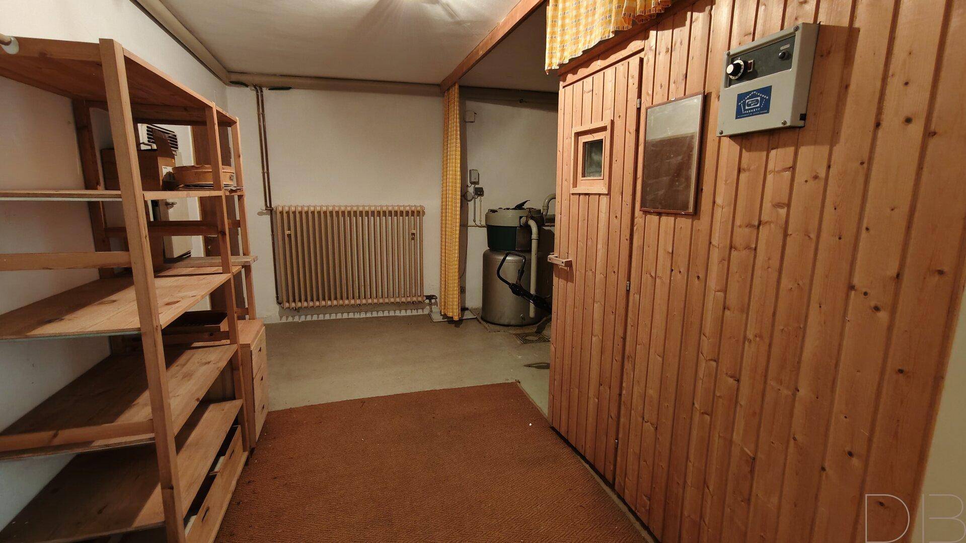 Kellerraum mit Holzregalen und einer sichtbaren Sauna, ideal für Wellness.