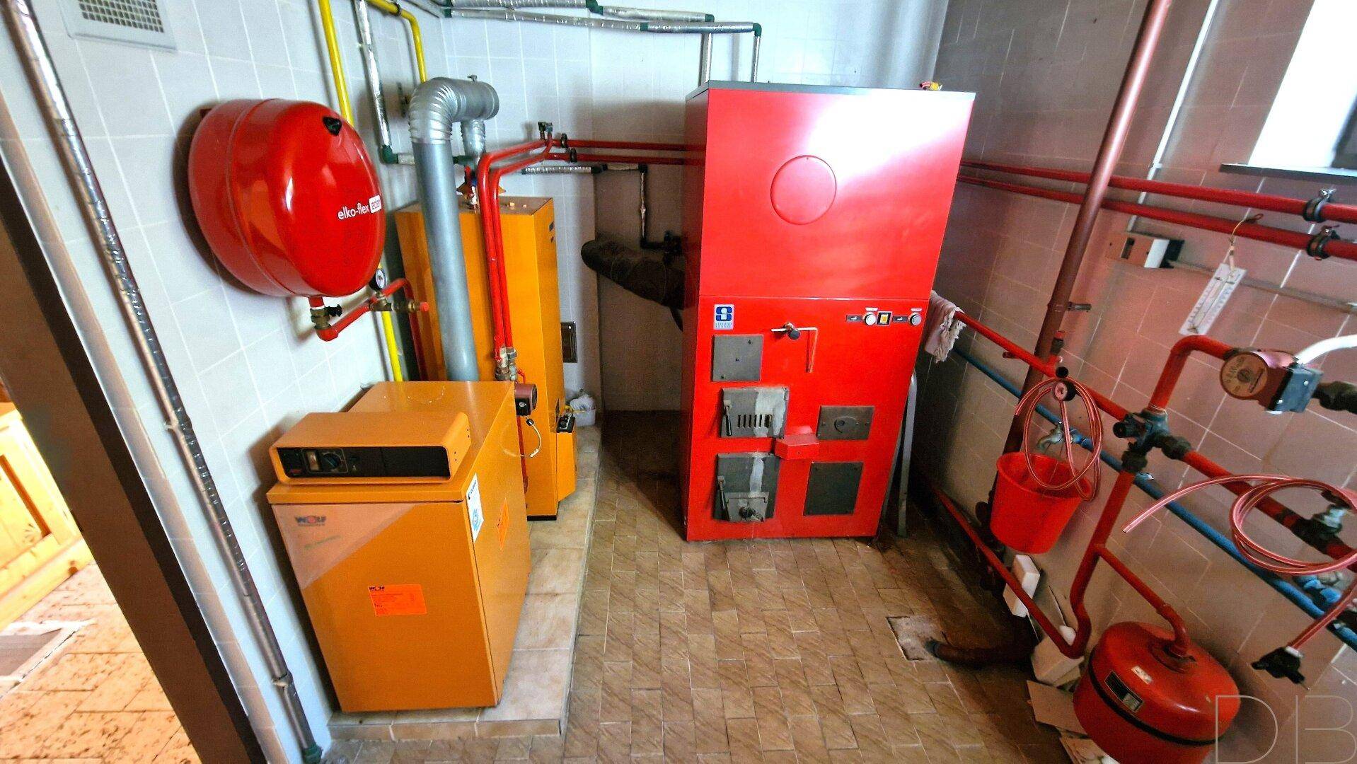 Heizungsraum mit Kesseln und Rohren, typisch für einen Technikraum im Keller.