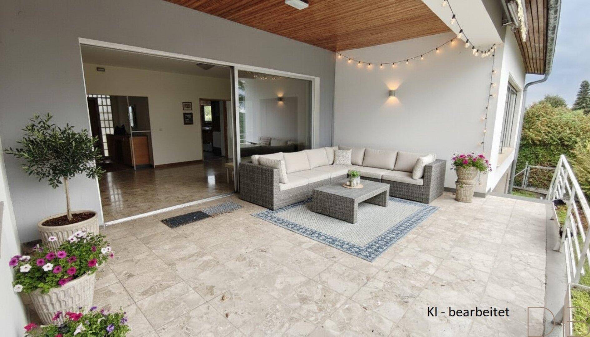 Große geflieste Terrasse mit bequemen Loungemöbeln, Pflanzen und Lichterkette, mit Zugang zum Innenbereich.