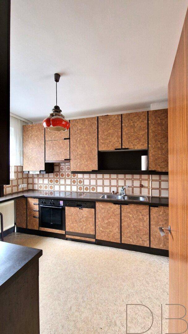 Küche im Retro-Stil mit gemusterten Fronten, Fliesenrückwand und Einbaugeräten.