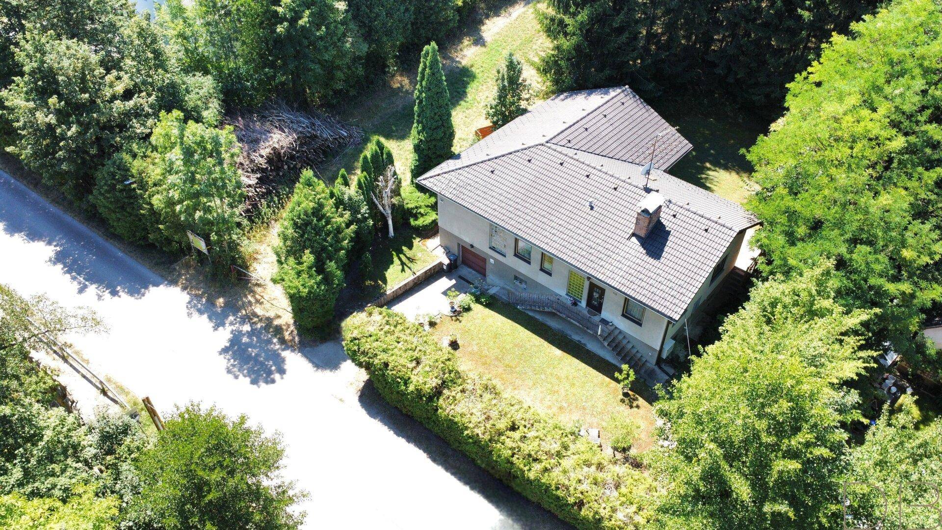 Übersichtliche Luftaufnahme des Hauses mit Garten und der umliegenden grünen Landschaft.
