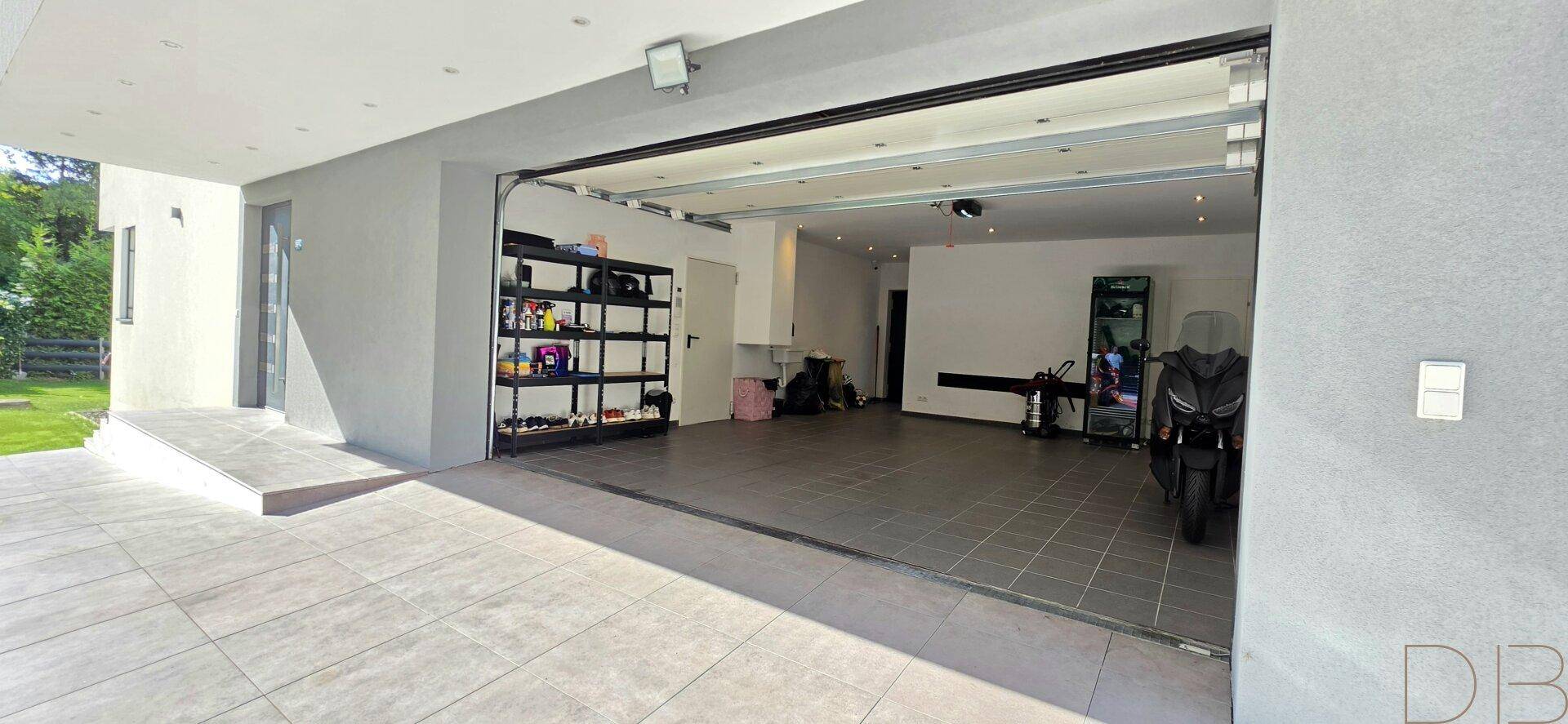 Geräumige Garage mit Fliesenboden, Stauraum und Platz für Fahrzeuge.