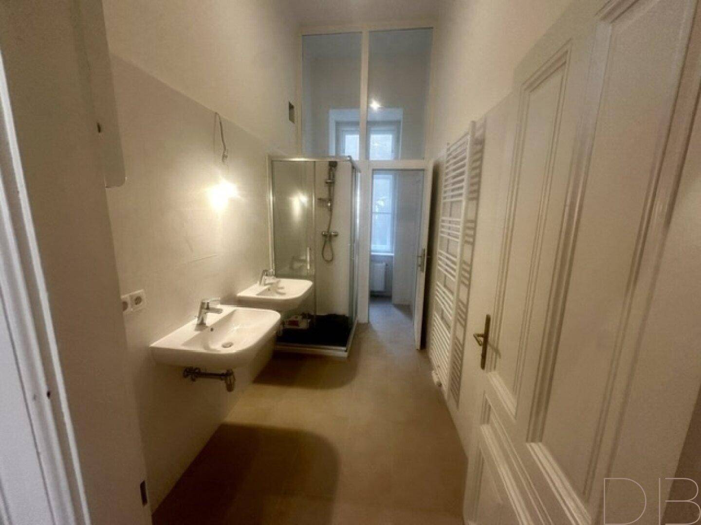 Modernes Badezimmer mit Doppelwaschbecken, Duschkabine und beheiztem Handtuchhalter.