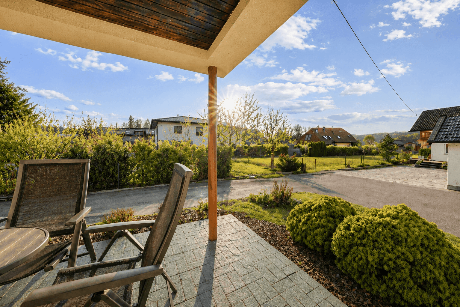 Überdachte Terrasse mit Sitzgelegenheiten und weitem Blick ins Grüne.