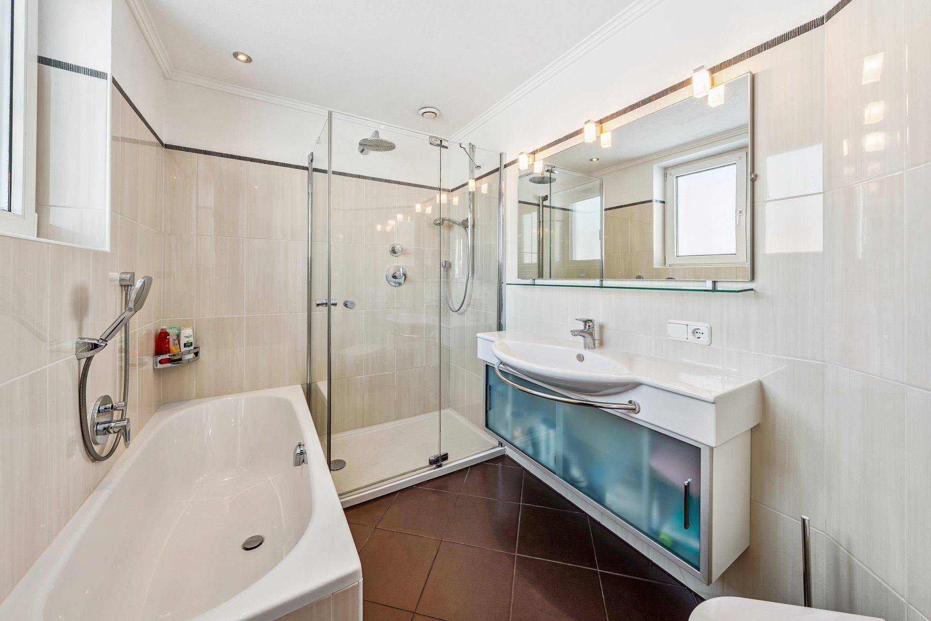Modernes Badezimmer mit Badewanne, Glasdusche und großem Waschtisch mit Spiegelschrank.