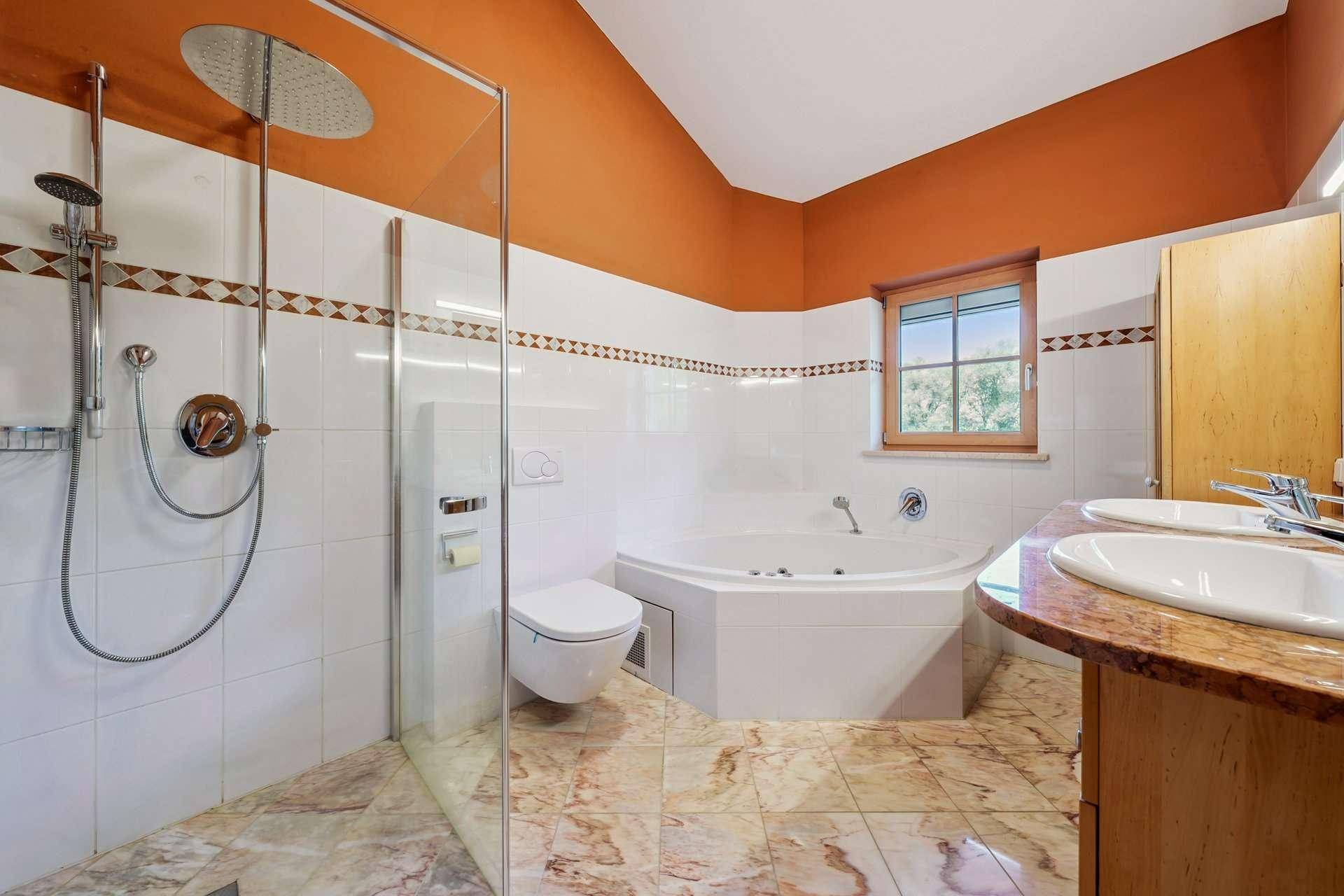 Badezimmer mit moderner Duschkabine, Eckbadewanne und Doppelwaschbecken.