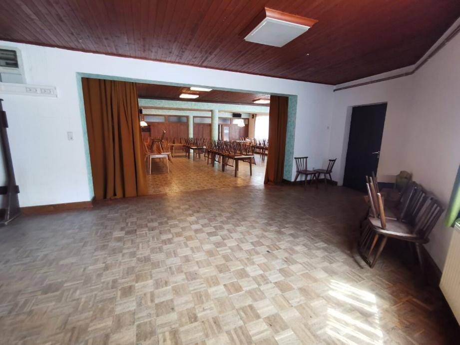 Großer Speisesaal mit Holzdecke, Parkettboden und vielen Tischen und Stühlen, bereit für Gäste.