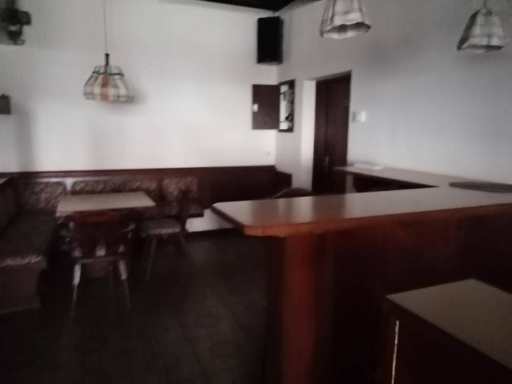 Gemütlicher Barbereich mit Holzbänken, Tischen und traditionellen Lampen, ideal für gesellige Runden.