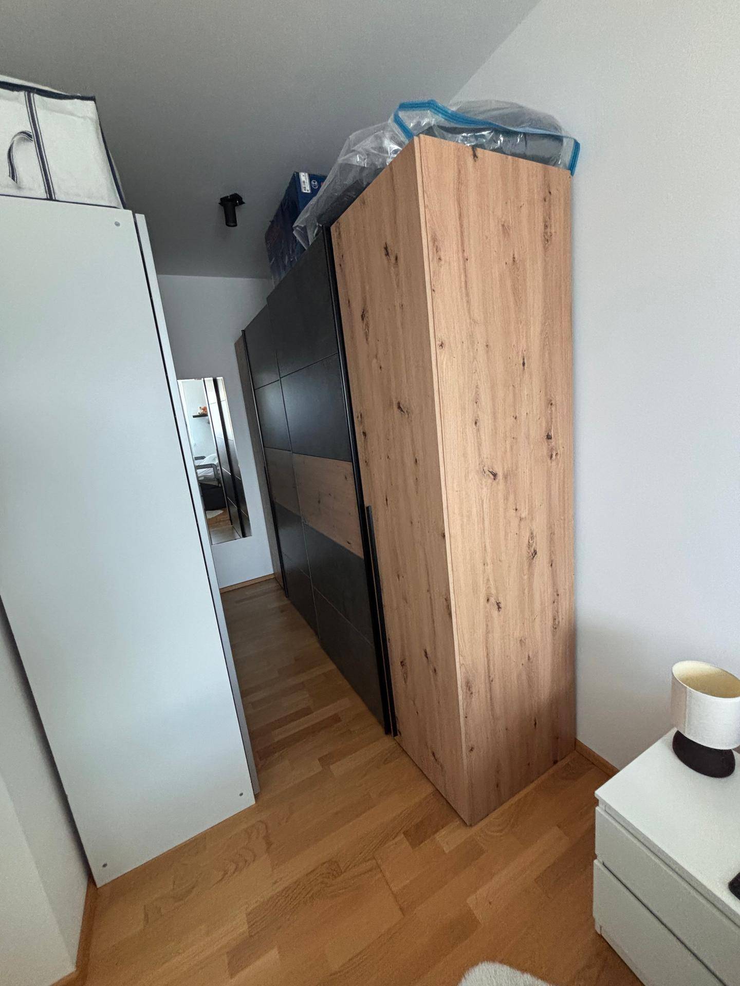 Schmaler Flur mit großem Holzschrank und Spiegel, der den Raum optisch erweitert.