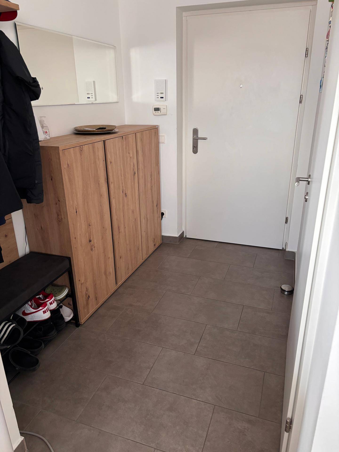 Eingangsbereich mit praktischem Schuhschrank, Garderobe und pflegeleichten Fliesen.