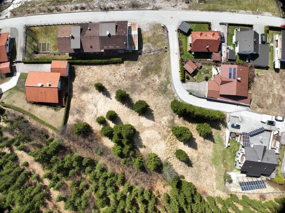 Übersicht aus der Luft auf die Bebauung und die angrenzenden grünen Hügel.