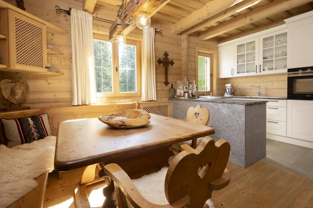 Gemütlicher Essbereich mit Holztisch und Bänken, angrenzend an die moderne Küche.