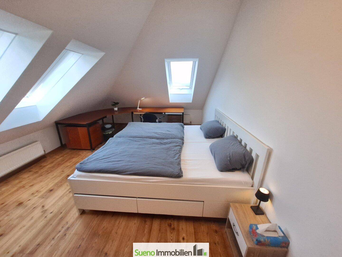 Gemütliches Schlafzimmer im Dachgeschoss mit Doppelbett, Holzboden und Dachfenstern.