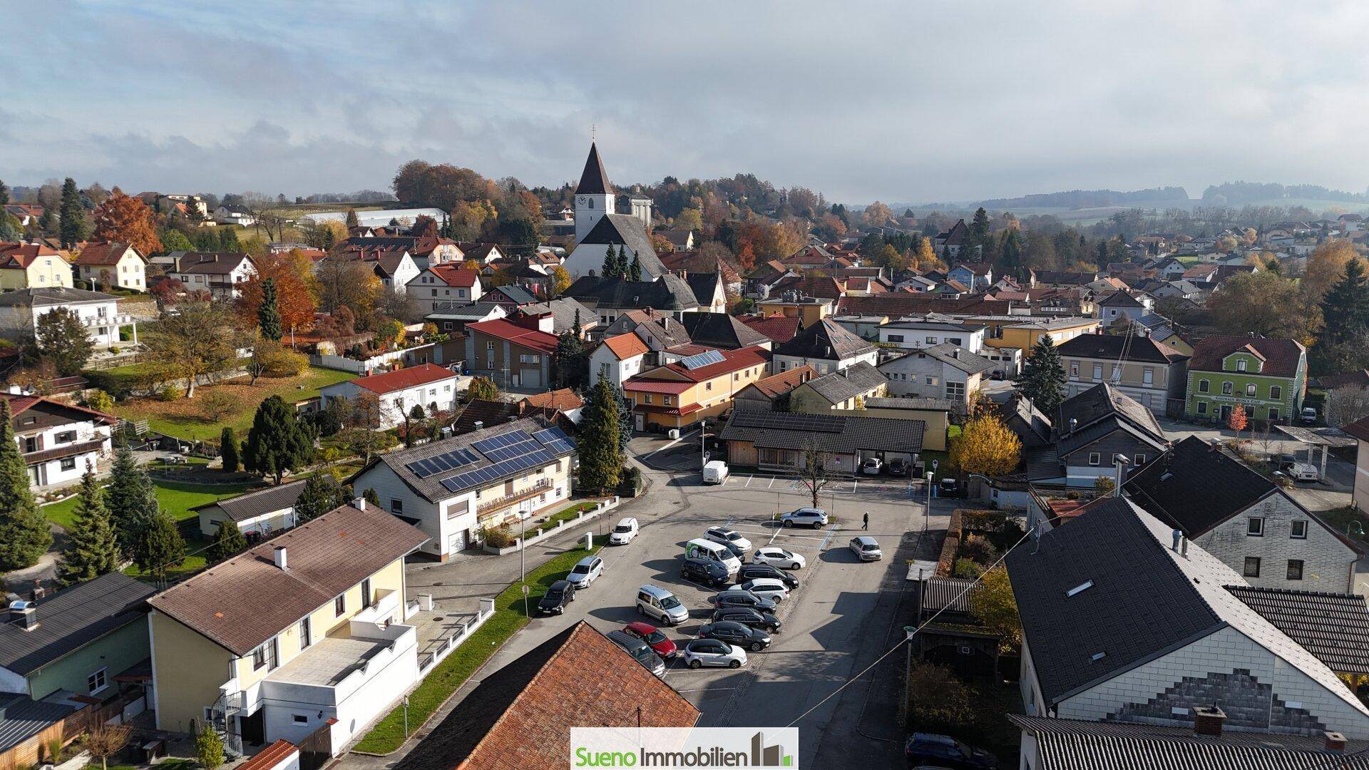 Panoramablick auf eine ländliche Stadt mit Kirche und Wohngebäuden.