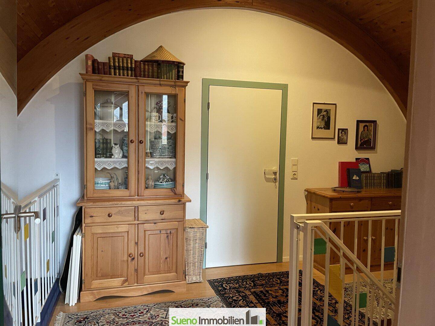 Flur im Obergeschoss mit Holzboden, gewölbter Decke und rustikalem Holzschrank.