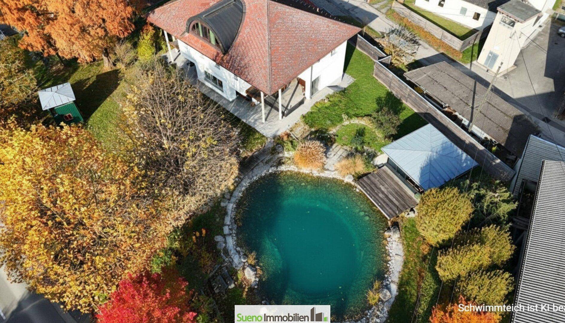 Luftaufnahme des gesamten Anwesens mit Haus, großem Garten und dem türkisfarbenen Schwimmteich.