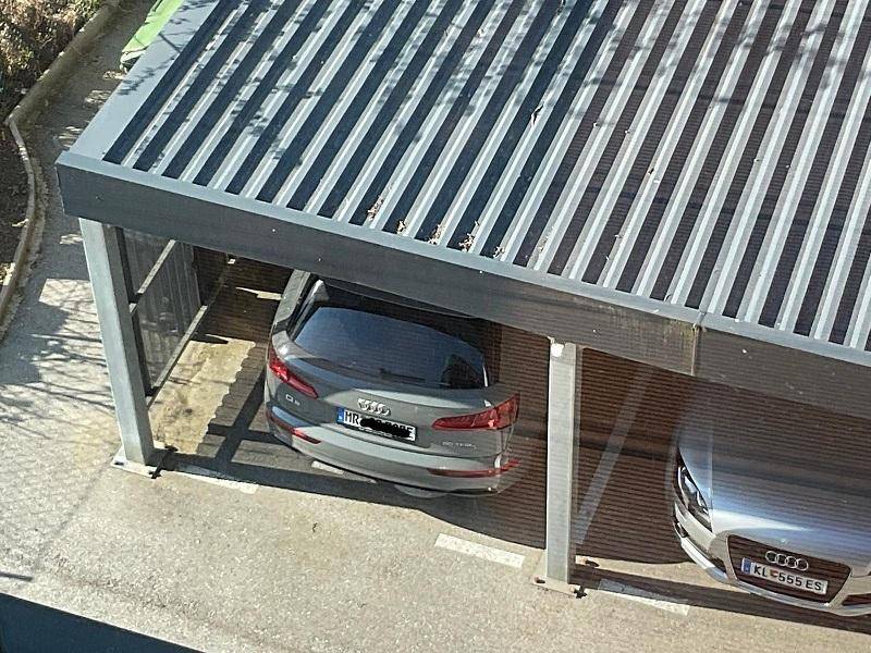 Überdachter Stellplatz für zwei Fahrzeuge unter einem modernen Carport.